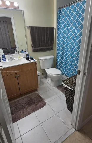 a bathroom with a sink a toilet a mirror and shower