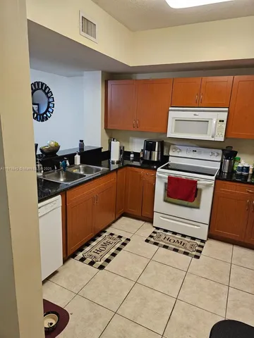 a kitchen with stainless steel appliances a sink stove top oven and cabinets