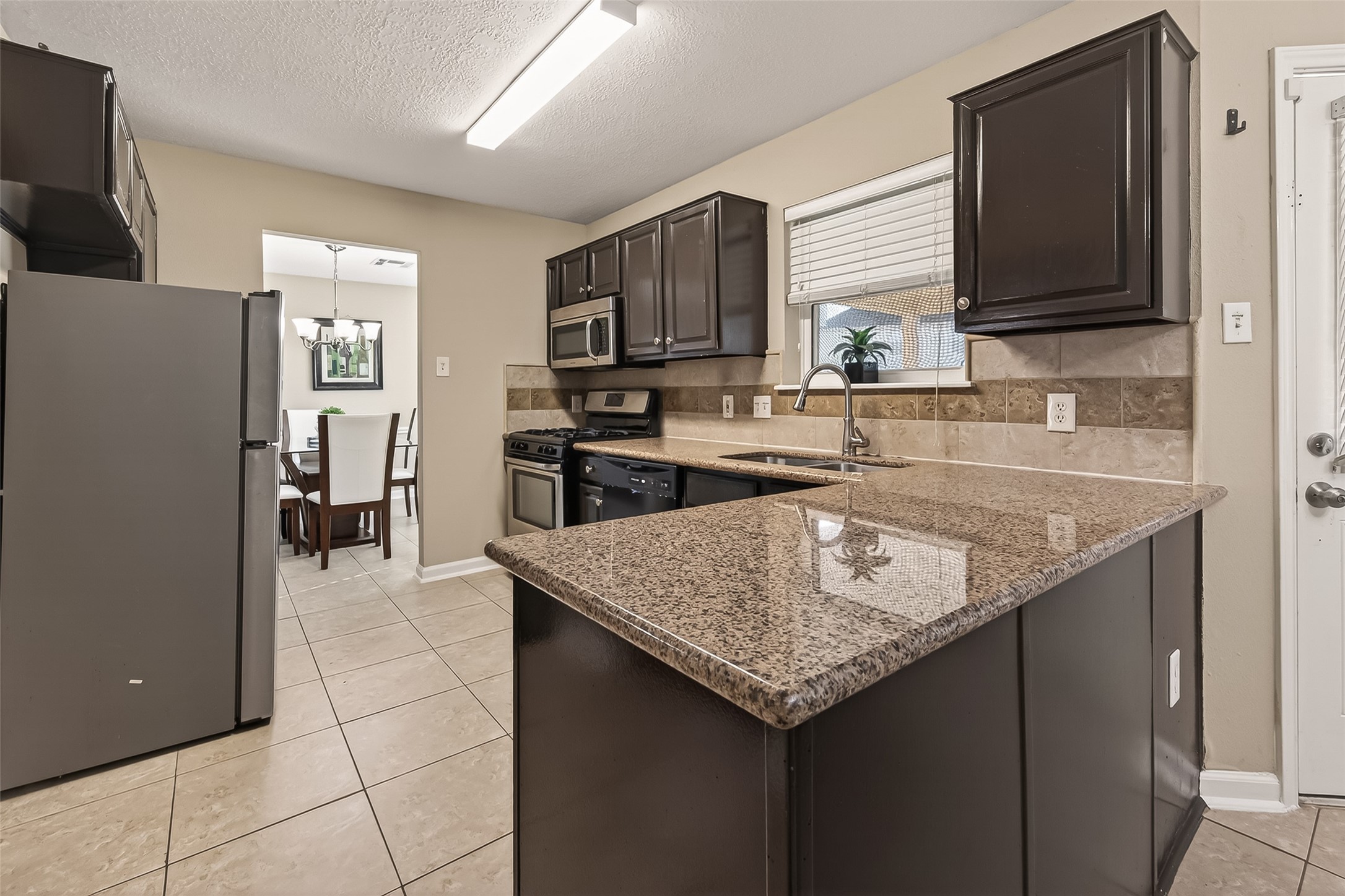 618 Bold Ruler Drive Stafford, TX 77477 - Photo 12 of 35 a kitchen with stainless steel appliances granite countertop a sink stove and refrigerator