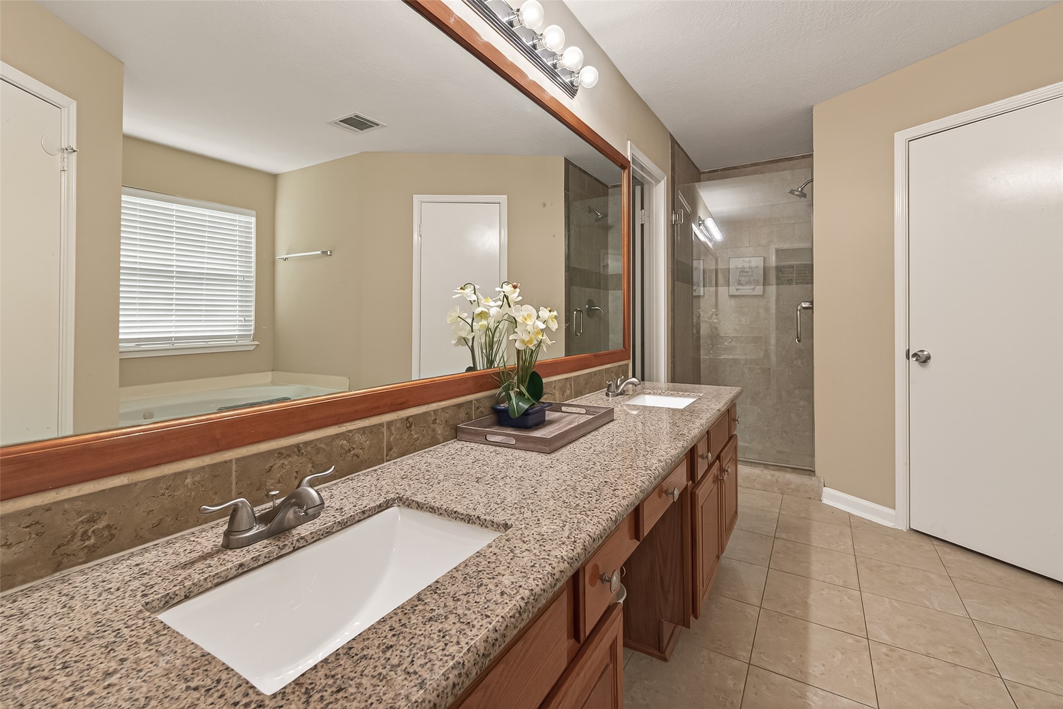 618 Bold Ruler Drive Stafford, TX 77477 - Photo 30 of 35 a bathroom with a granite countertop sink a mirror and a shower