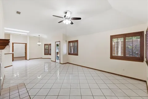 a view of an empty room with window and fireplace