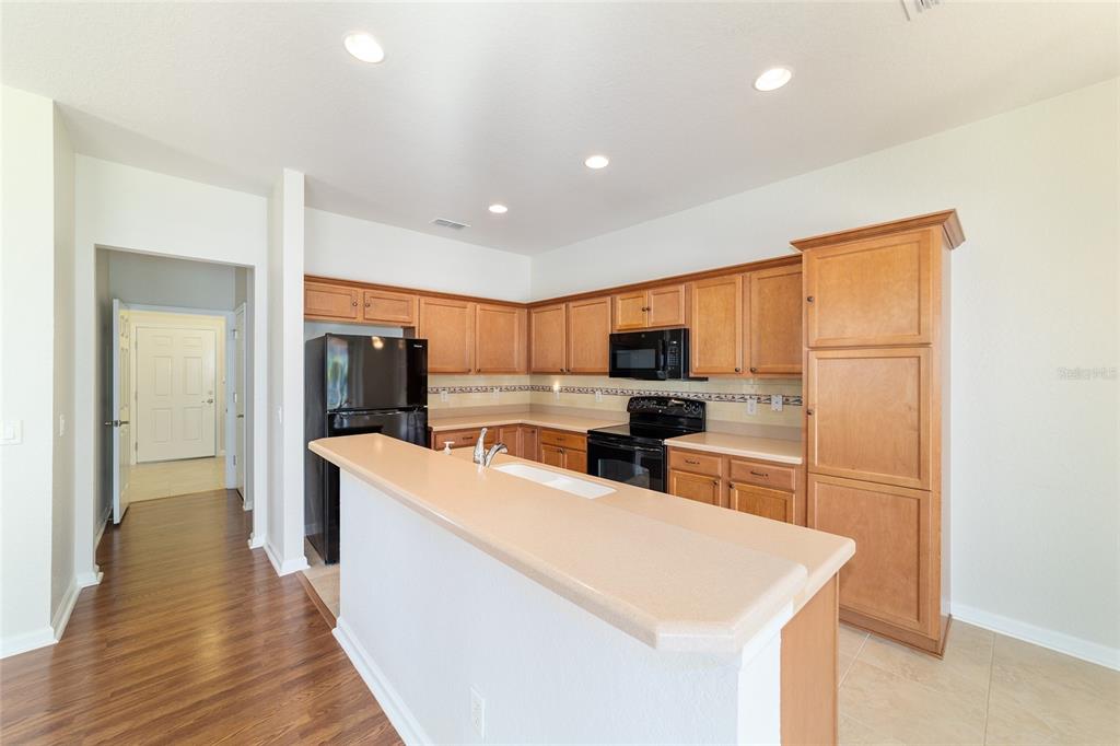 7153 Southwest 93rd Avenue Ocala, FL 34481 - Photo 23 of 61 a kitchen with stainless steel appliances white cabinets and wooden floor
