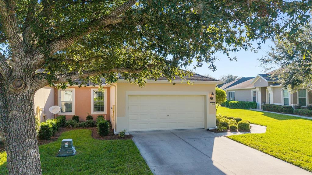 7153 Southwest 93rd Avenue Ocala, FL 34481 - Photo 3 of 61 a front view of a house with a yard and trees