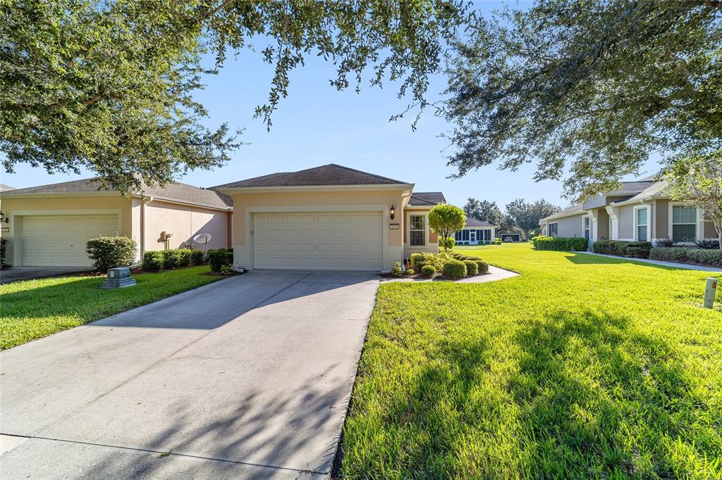 7153 Southwest 93rd Avenue Ocala, FL 34481 - Photo 5 of 61 a front view of a house with a yard and trees