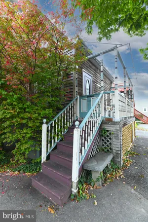a view of a house with a yard and wooden fence