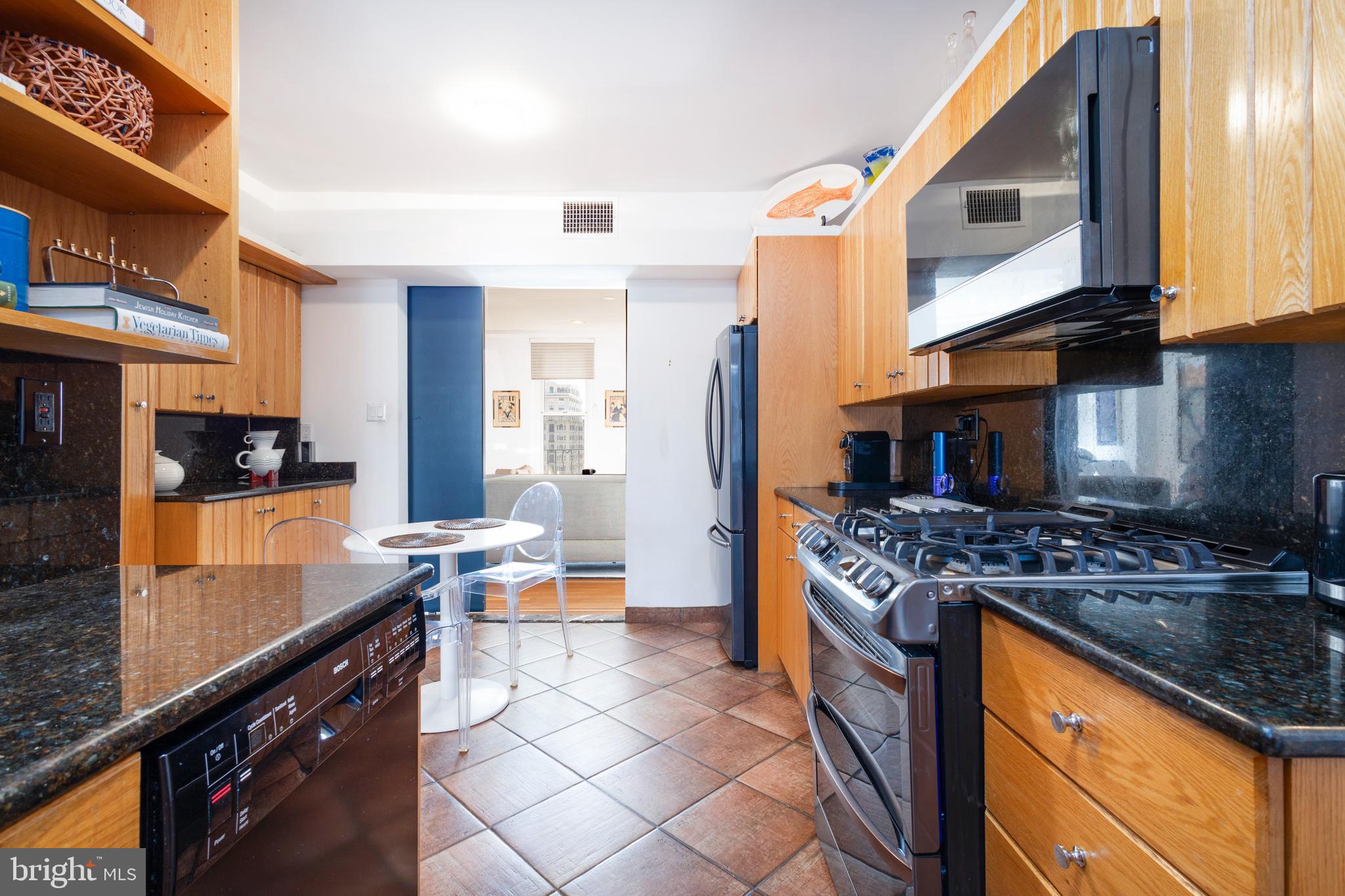 1901 Walnut Street, Unit 15B Philadelphia, PA 19103 - Photo 11 of 36 a kitchen with stainless steel appliances granite countertop a stove a sink and a microwave