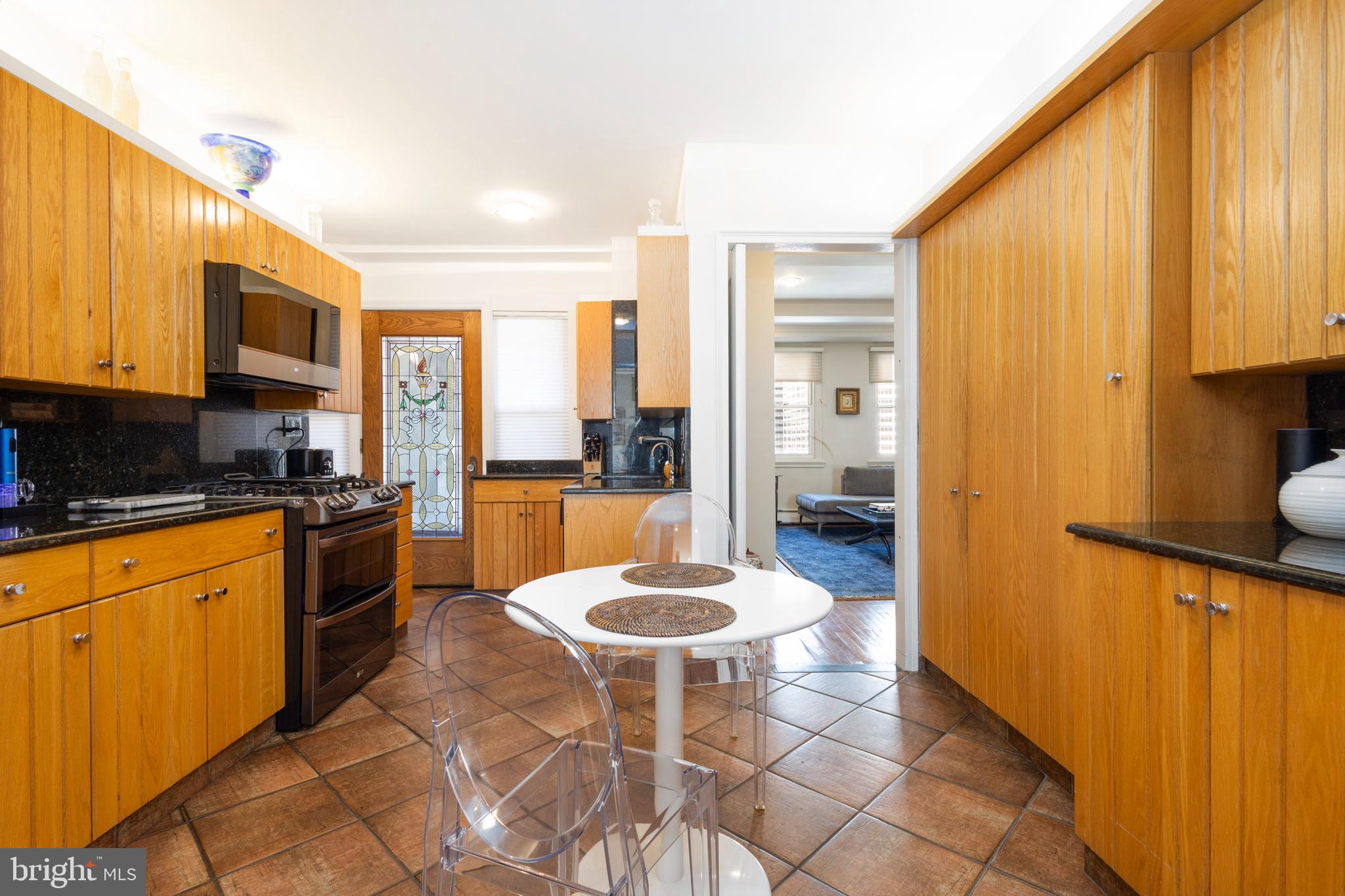 1901 Walnut Street, Unit 15B Philadelphia, PA 19103 - Photo 13 of 36 a kitchen with a refrigerator a stove top oven a sink dishwasher and wooden cabinets