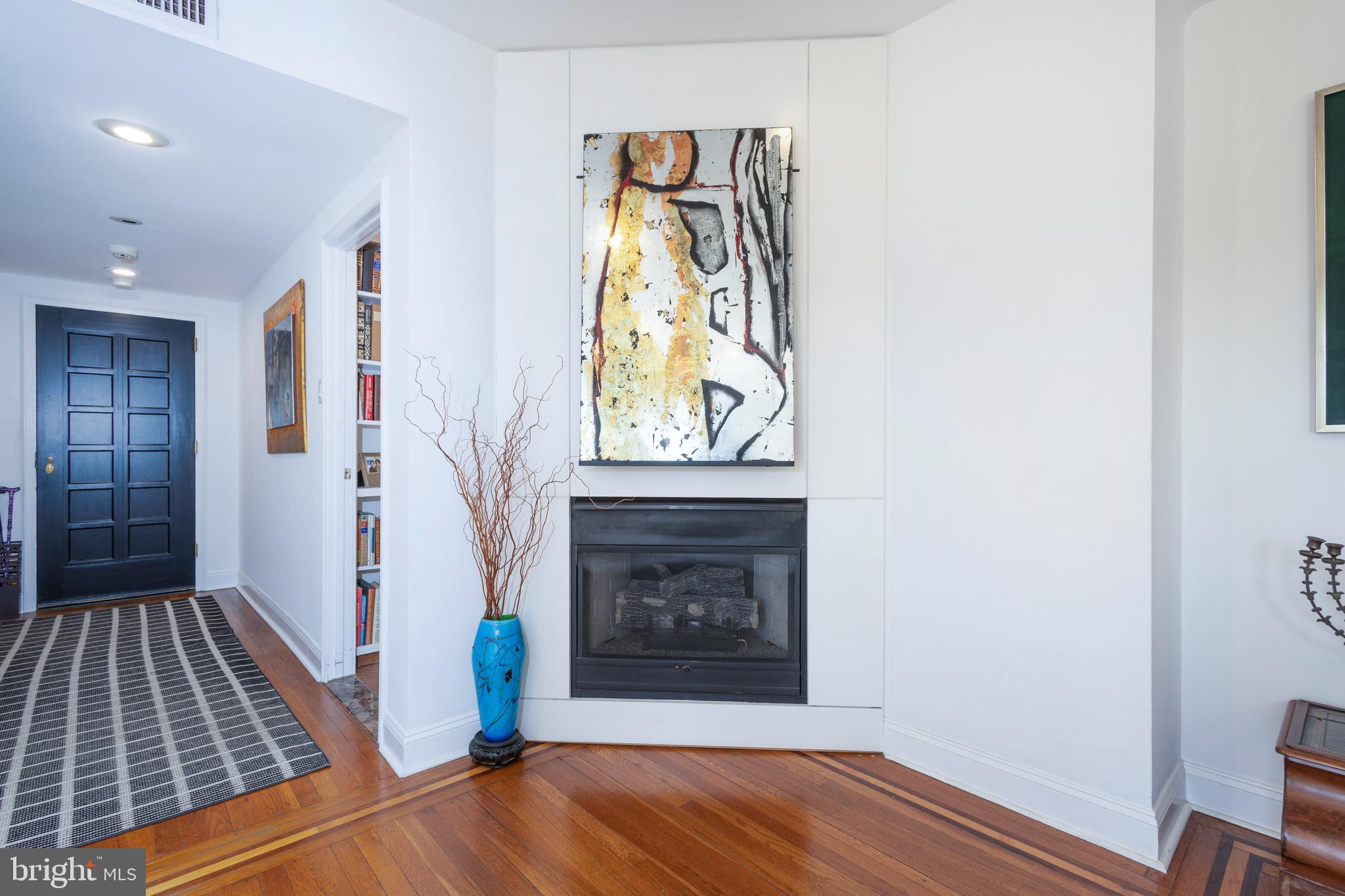 1901 Walnut Street, Unit 15B Philadelphia, PA 19103 - Photo 4 of 36 a view of a hallway with wooden floor and a fireplace