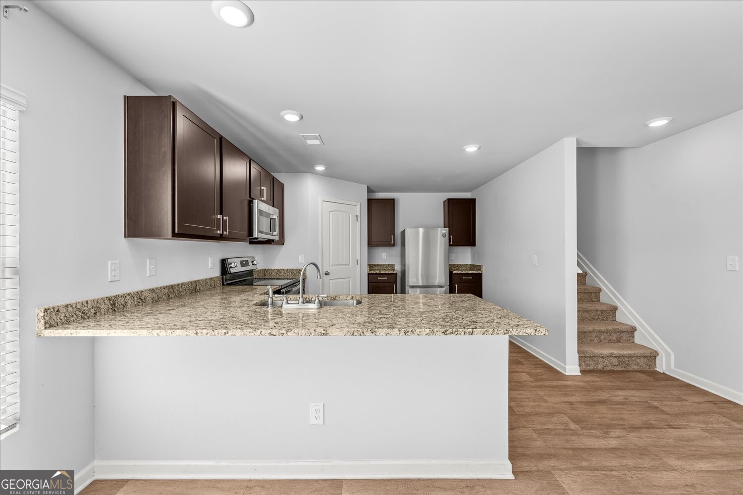 89 Cowpen Court Covington, GA 30014 - Photo 13 of 44 a view of a kitchen with kitchen island a sink stainless steel appliances and cabinets