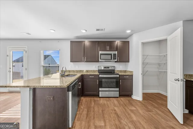 a kitchen with stainless steel appliances granite countertop a sink stove and refrigerator