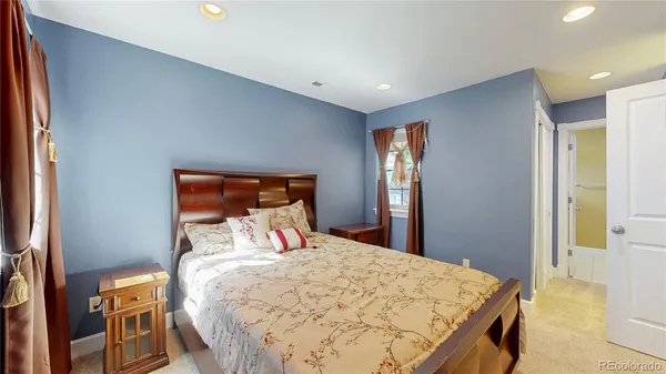 a bedroom with a bed and a lamp on dresser