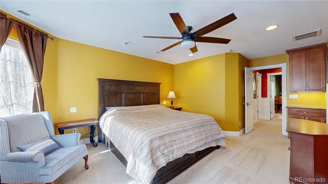 a bedroom with a bed a couch and a flat screen tv