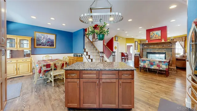 a kitchen with stainless steel appliances granite countertop a refrigerator a sink dishwasher a stove and white countertops with wooden floor