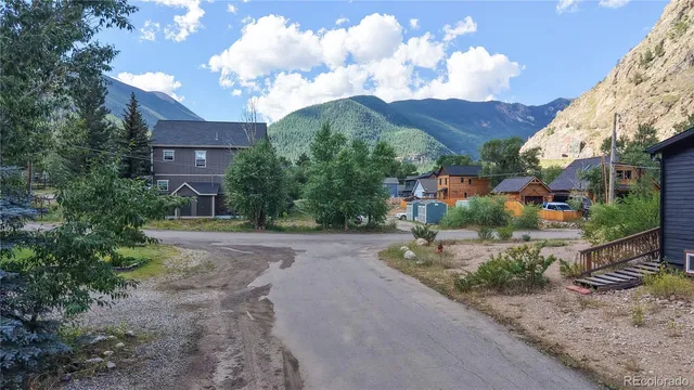 a view of a house with a small yard and a large tree
