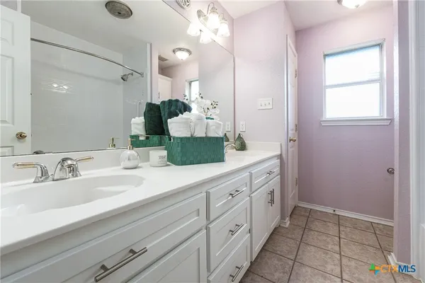 a spacious bathroom with 2 sink and a mirror