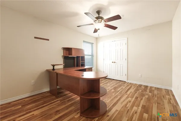 a view of a room with wooden floor fan and window