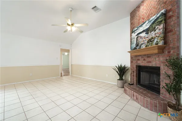 a view of a livingroom with a fireplace and chandelier fan