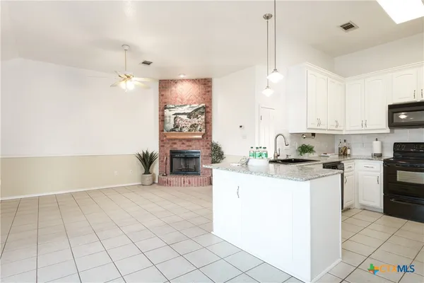 a kitchen with cabinets and chairs