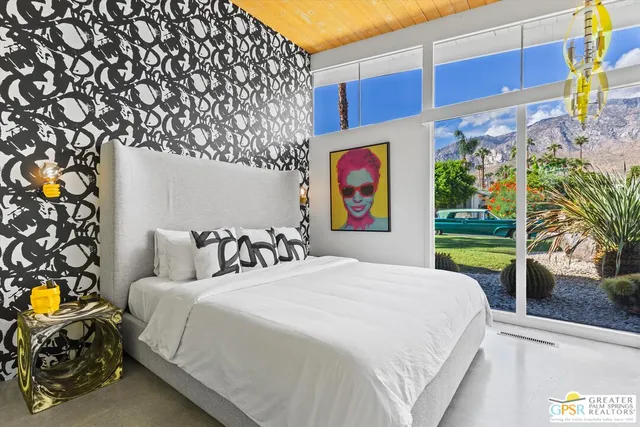 a large bed sitting in a bedroom next to a window