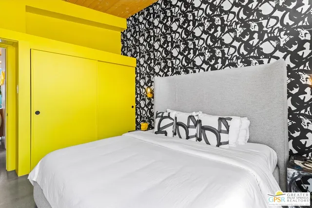 a bedroom with a bed and a painting on the wall