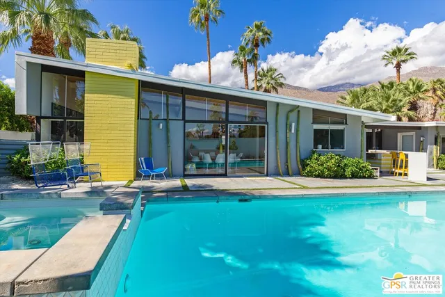 a view of a house with backyard and sitting area