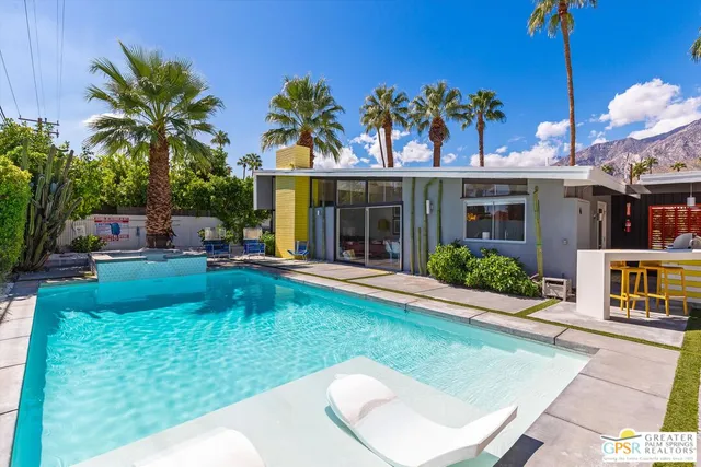 a view of a house with a swimming pool and sitting area