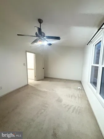 a view of an empty room with a chandelier fan