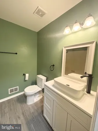 a bathroom with a sink a toilet and a mirror