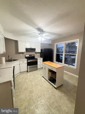 a kitchen with granite countertop a stove and cabinets