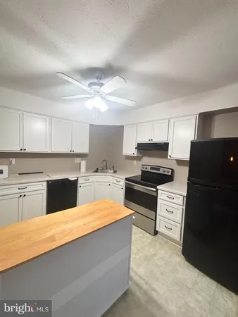 a large kitchen with cabinets appliances and a counter space