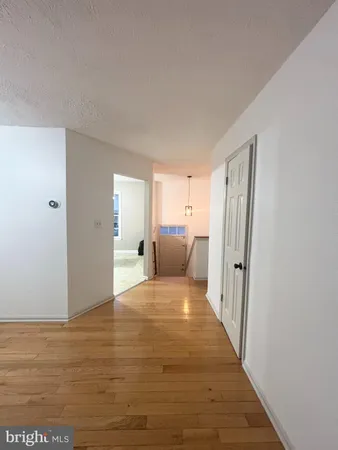 a view of a bedroom with wooden floor and windows