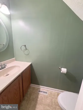 a bathroom with a sink mirror vanity and toilet