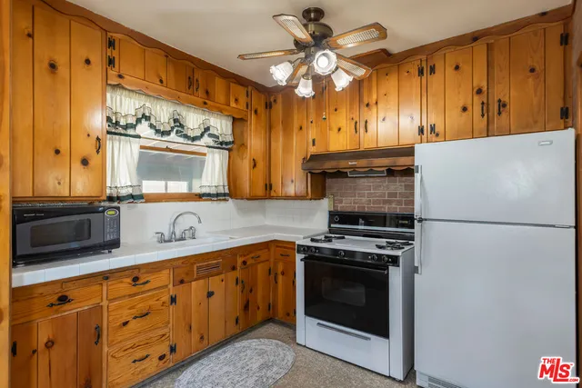 a kitchen with stainless steel appliances a stove a sink and a refrigerator