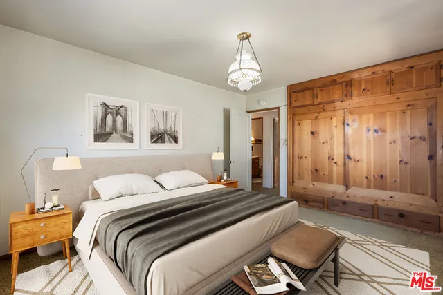 a bedroom with a bed and a chandelier