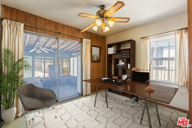 an empty room with windows and fan