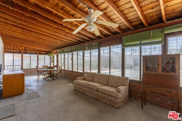 a view of a patio with a dining table and chairs with wooden floor