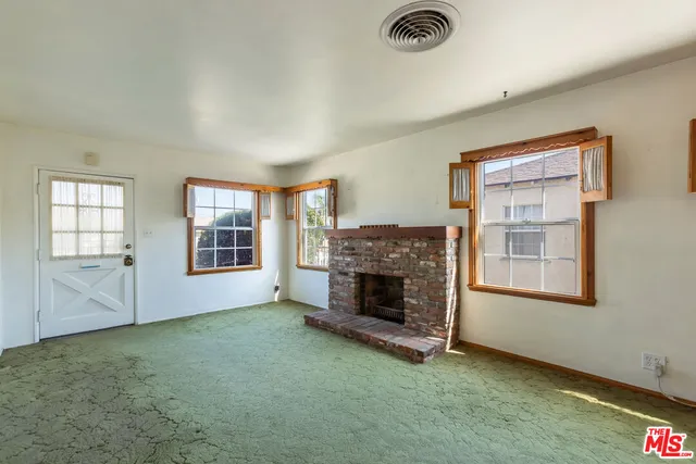a view of livingroom with furniture fireplace and window
