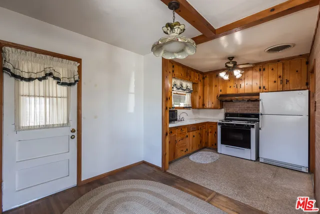 a kitchen with a refrigerator and a stove top oven