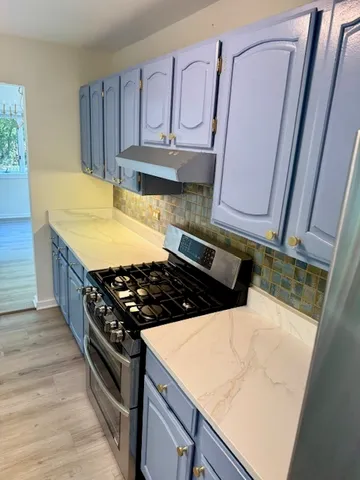 a kitchen with wooden cabinets a sink and a stove