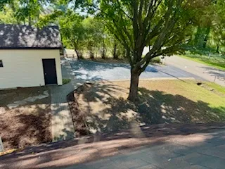 a view of a house with a big yard and large trees