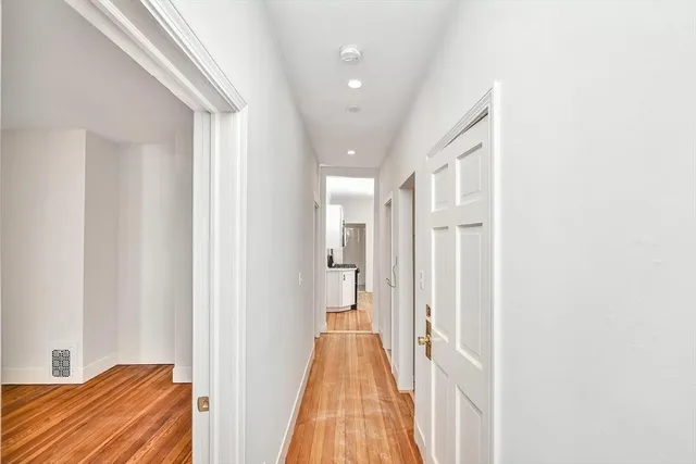 a view of a hallway with wooden floor and closet
