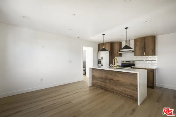 a kitchen with stainless steel appliances a stove top oven a sink and white cabinets