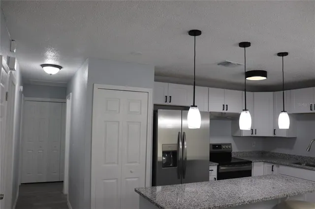 a kitchen with kitchen island a counter top space appliances and cabinets