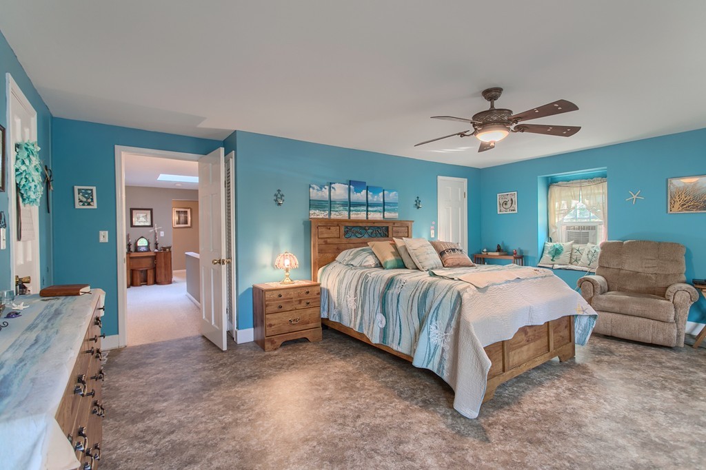 318 Patriots Road Templeton, MA 01468 - Photo 24 of 30 a spacious bedroom with a bed a couch and a chandelier