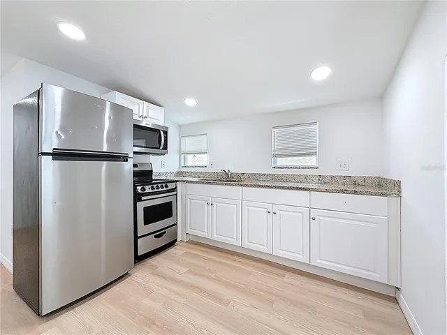 a kitchen with a refrigerator stove and sink