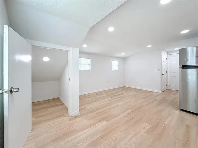 a view of empty room with wooden floor