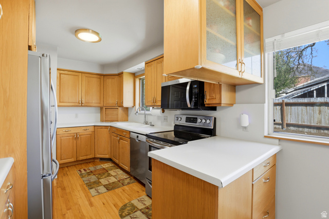 4245 3320 East Holladay, UT 84124 - Photo 19 of 51 Kitchen featuring wood cabinetry, white countertops, stainless steel appliances, a double basin sink, and wood-finish flooring