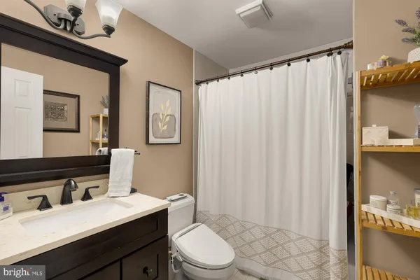 a bathroom with a sink vanity mirror and toilet