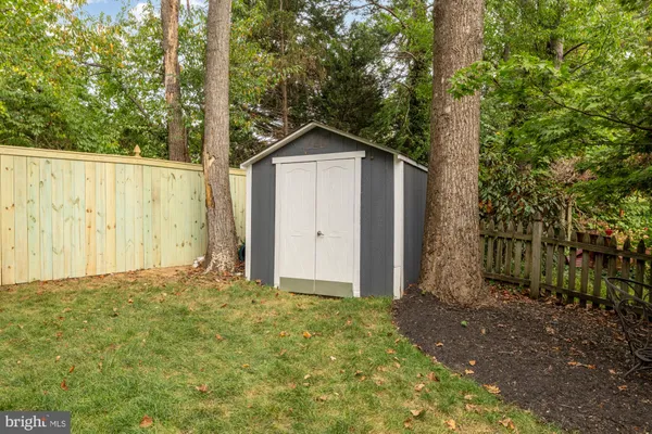 a view of wooden house and a yard with large trees