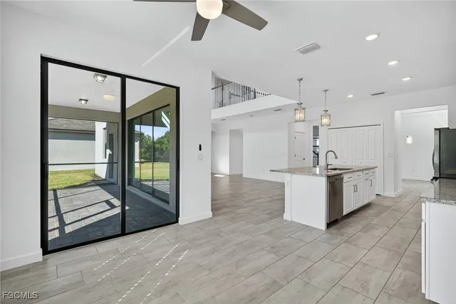 a large white kitchen with a large window and refrigerator